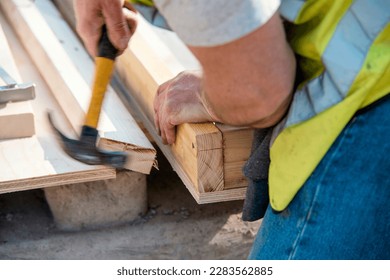 Carpenter hammering nail into the wood by hammer. Joiner with hammer and nail close-up - Shutterstock ID 2283562885