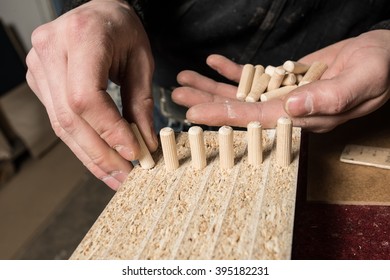 Carpenter Hammering Wood Dowel In A Piece Of Wood