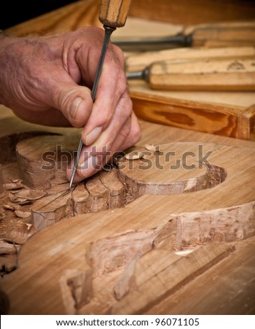 carpenter hand carving wood with care