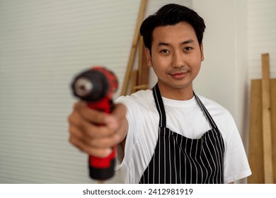 Carpenter handling battery-powered screw driving machine. Focus at face. - Powered by Shutterstock