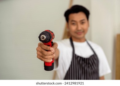 Carpenter handling battery-powered screw driving machine, focus at driver - Powered by Shutterstock