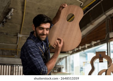 Carpenter holding raw guitar body with a smile, showing his craftsmanship in woodworking studio. Concept of handmade instruments, luthier, woodworking, creativity, and pride in skilled labor. - Powered by Shutterstock - Get 15% off with code: PIKWIZARD15