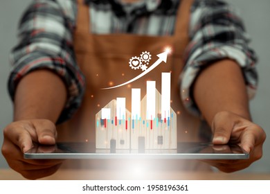 Carpenter holding tablet and wood house model is on screen tablet and illustration stock chart for new hight business real estate. Property hight sale graph dashboard with key performance indicators.