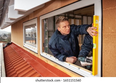 A Carpenter Installs A Window In A Low Energy House