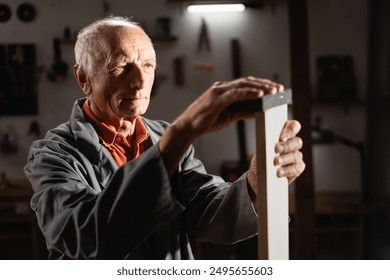 Carpenter joiner polishing wooden block with sanding sponge working in his workshop. Woodworking and carpentry business concept - Powered by Shutterstock