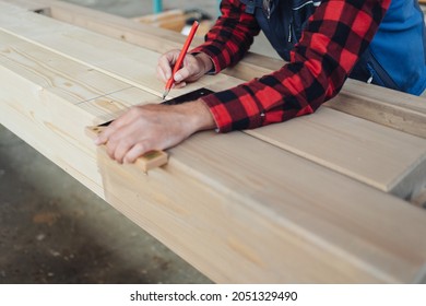 Carpenter Or Joiner Using A Right Angle Tool To Check A Beam Of Wood In A Carpentry Or Woodworking Workshop In A Close Up On His Hands