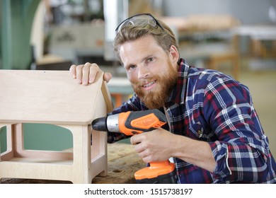 Carpenter Making A Bird Feeder