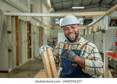 Carpenter man Portrait of Young black skin looking smile laugh to camera in workshop. Happy professional Carpenter holds wooden planks for build furniture in carpentry workshop. one carpenter worker - Powered by Shutterstock