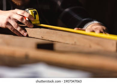 carpenter man using measuring tape looking wood size at workspace. craftsman profession in wood factory. - Powered by Shutterstock