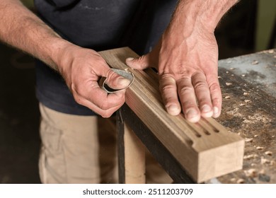 The carpenter manually sanded the milled part of the oak part with sandpaper closeup - Powered by Shutterstock