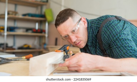 Carpenter measures wooden planks in the workshop. - Powered by Shutterstock