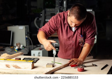 Carpenter measuring chair part with electric callipers in workshop. - Shutterstock ID 2256885153