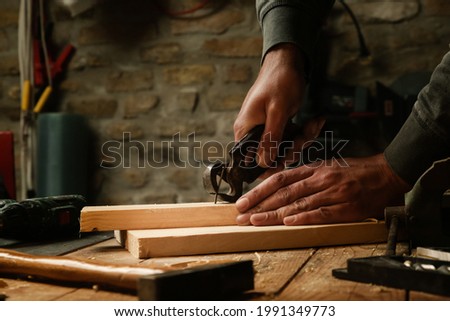 Carpenter pulling the nail with carpenters pincers.