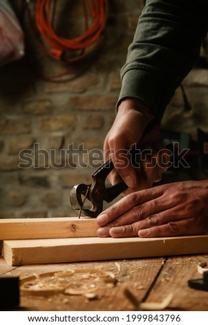 Carpenter pulling the nail with carpenters pincers.	