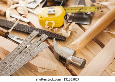 carpenter tools,hammer,meter,nails,shavings, and chisel over wood table