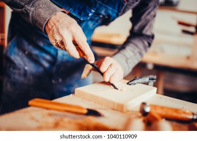 The carpenter uses a chisel for carving. Carving view. Toned image.