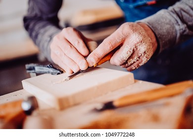 The carpenter uses a chisel for carving. Carving view. Toned image. from the front view
