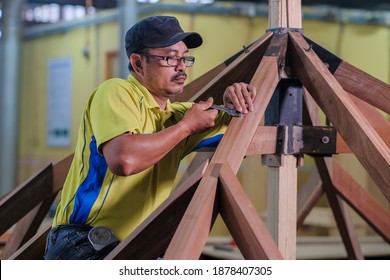 Carpenter Using Bolt And Nut In Installation Of Roof Rafters On A New Gazebo Construction Project .