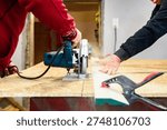 Carpenter using circular saw for cutting wooden OSB board. 