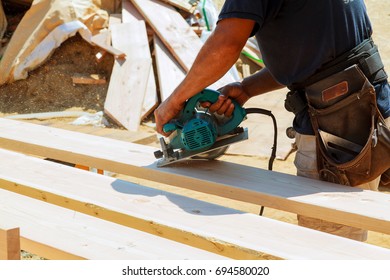 Carpenter using circular saw for cutting wooden boards. Construction details of male worker or handy man with power tools