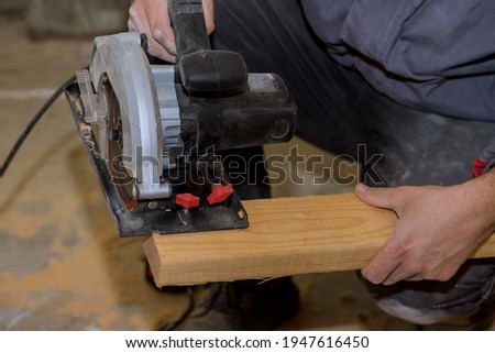 Carpenter using circular saw for wood beam a new home constructiion project