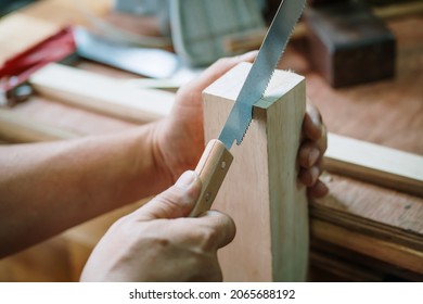 Carpenter Using Japanese Saw Or Pull Saw ,Crosscutting On Wood On Table,woodworking Concept 