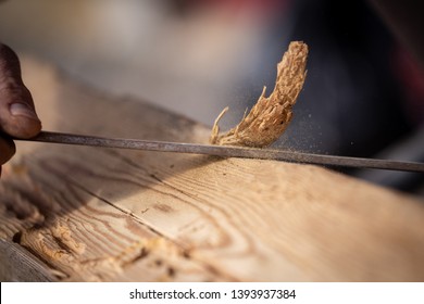 Carpenter Using A Manual Bark Peeler To Shape An Old Reclaimed Oak Wood Beam