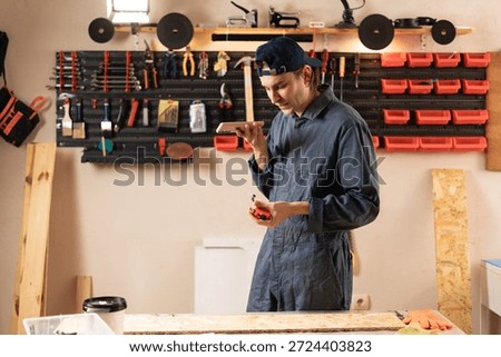 carpenter using mobile phone in workshop. craftsman dictate voicemail in hardwood work, online message. copy space