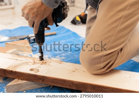A carpenter using power tools to work with wood
