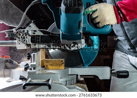 Carpenter using professional circular saw with a miter in the woodcraft carpentry workshop. 