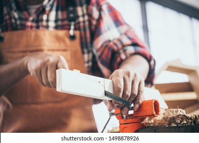 A Carpenter Is Using A Saw To Work In A Woodworking Studio