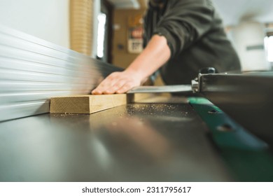 carpenter using a table saw while working in his woodworking studio, extreme closeup shot. High quality photo