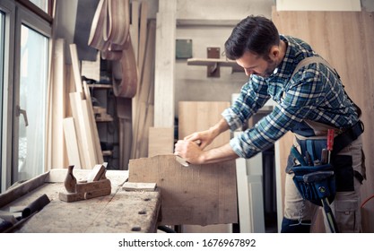 Carpenter using woodworking tools for craft work in carpentry workshop - Powered by Shutterstock