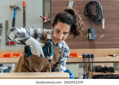 Carpenter woman one smile young aged standing aim working on wood plank in carpenter workshop. Latin female carpenter entrepreneur working craft with wood DIY tool in workbench carpenter workshop - Powered by Shutterstock