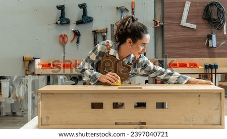 Carpenter woman one smile young aged standing aim working on wood plank in carpenter workshop. Latin female carpenter entrepreneur working craft with wood DIY tool in workbench carpenter workshop