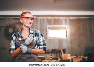 Carpenter woman wearing gloves and eye protection standing smile in wood workshop. - Powered by Shutterstock