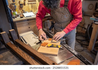 Carpenter work in furniture workshop, using ruler, caliper to cut pieces of natural leather for gluing to bed leg bases. Craftsmanship, material preparation, woodwork, furniture design, tool of trade - Powered by Shutterstock