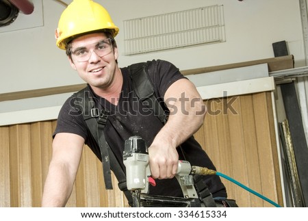 A Carpenter at work on job using power tool