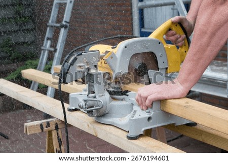 Carpenter at work outdoors on a  constructionsite. Craftsman at work with different tools. Building materials. Sawing machine