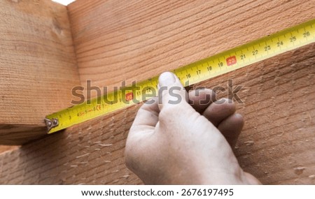 Carpenter at work outdoors on a  constructionsite. Craftsman at work with different tools. Building materials. Wood construction with beams. Measuring, tape measure