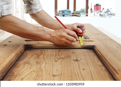 carpenter work the wood, measuring a wooden vintage door - Shutterstock ID 1103985959