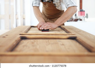 carpenter work the wood with the sandpaper - Powered by Shutterstock