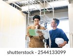 Carpenter and worker consulting at a construction site