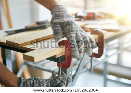Carpenter working with a C-clamp on the work bench