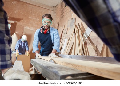 Carpenter working with circular saw at carpentry workshop