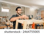 Carpenter working with electric planer on wooden plank in workshop. Craftsman makes own successful small business, man using tool in carpenter