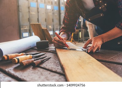 Carpenter working with equipment on wooden table in carpentry shop. woman works in a carpentry shop. - Shutterstock ID 1409924756