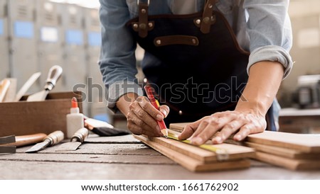 Carpenter working with equipment on wooden table in carpentry shop. woman works in a carpentry shop.