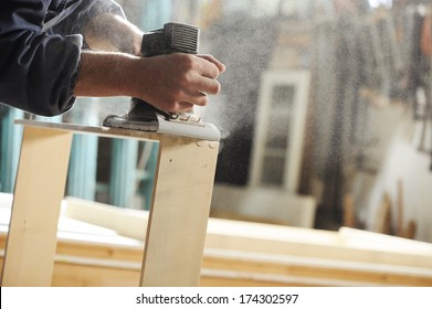 Carpenter Working On A Piece Of Furniture With A Planer.