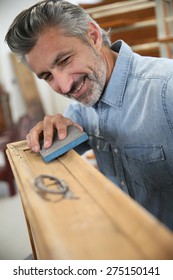 Carpenter Working On Recycling Wood Furniture